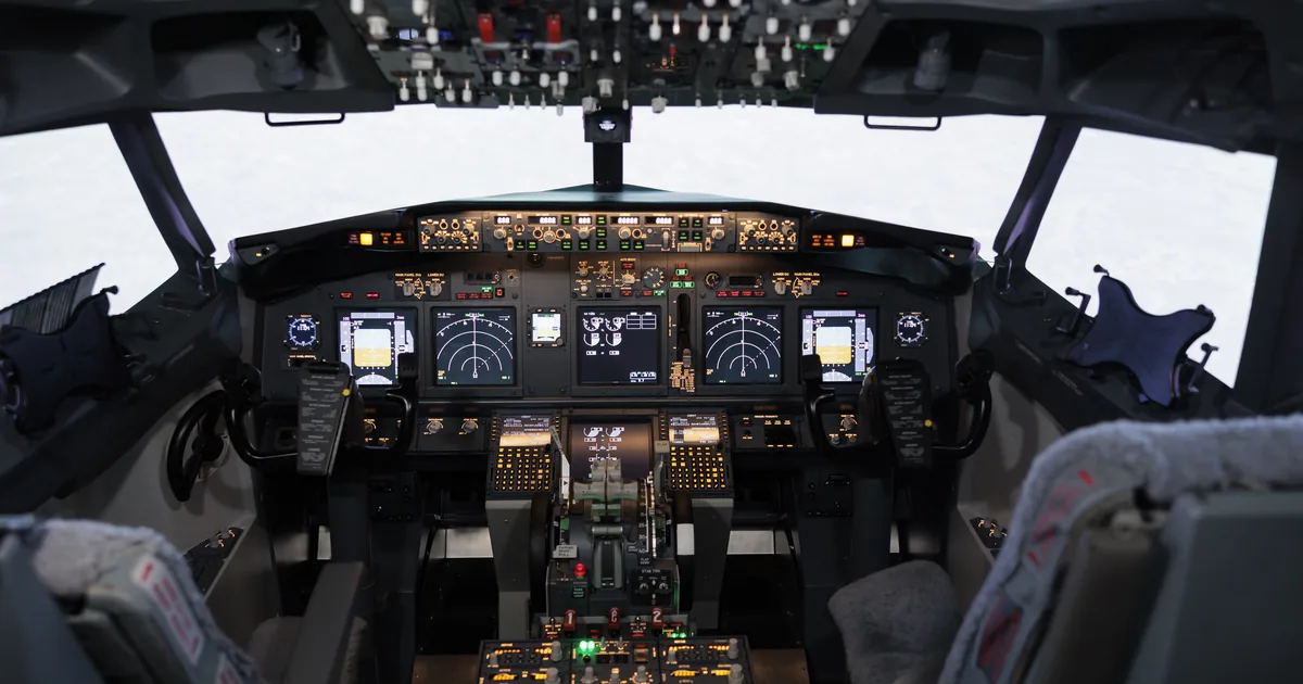 An empty aircraft cockpit showing full instrument displays, illustrating automation that still leaves the operator able to read the instruments.