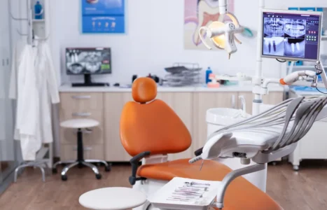 Interior of a modern UK dental surgery with treatment chair and equipment, illustrating AiBoost's analysis of dental paid advertising costs and rules.