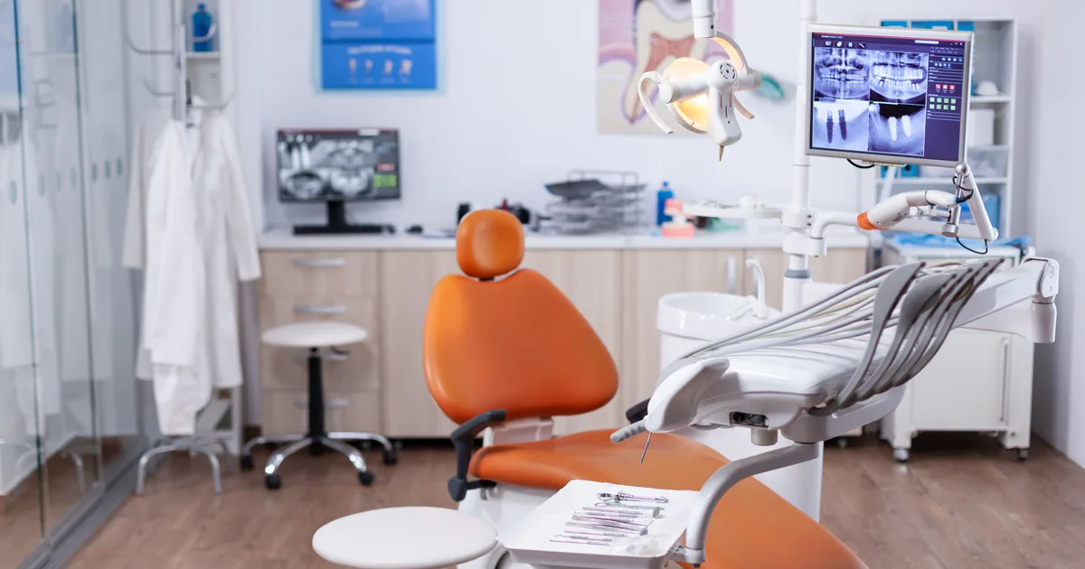 Interior of a modern UK dental surgery with treatment chair and equipment, illustrating AiBoost's analysis of dental paid advertising costs and rules.